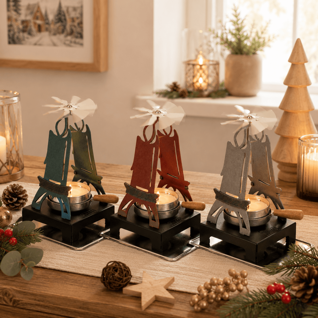 Three HUSS Incense pyramids with spinning wings on a wooden table and Christmas decor.