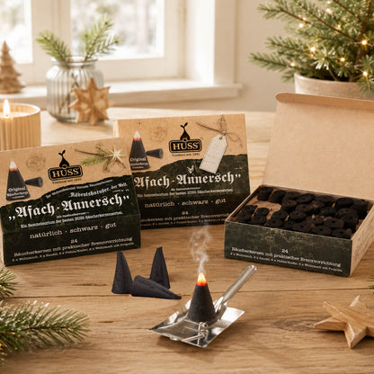 HUSS Incense boxes with several cones as Advent calendar with a cone smoking on a shovel holder, displayed on a wooden table.