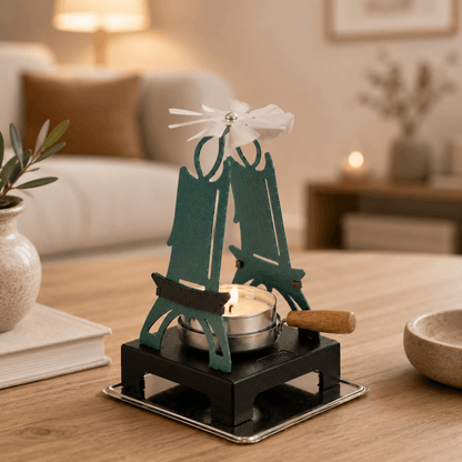 HUSS Incense green pyramid candle holder with a lit tealight and spinning wing displayed on a wooden table.