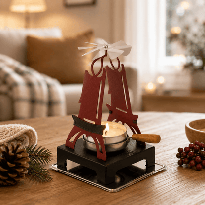 HUSS Incense pyramid candle holder in rustic red with a spinning wing and lit tealight displayed on a wooden table in a cozy living room scene.