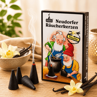 A box of HUSS Incense cones in Vanilla flavor, styled on a wooden table with incense cones smoking, vanilla beans, and flowers.