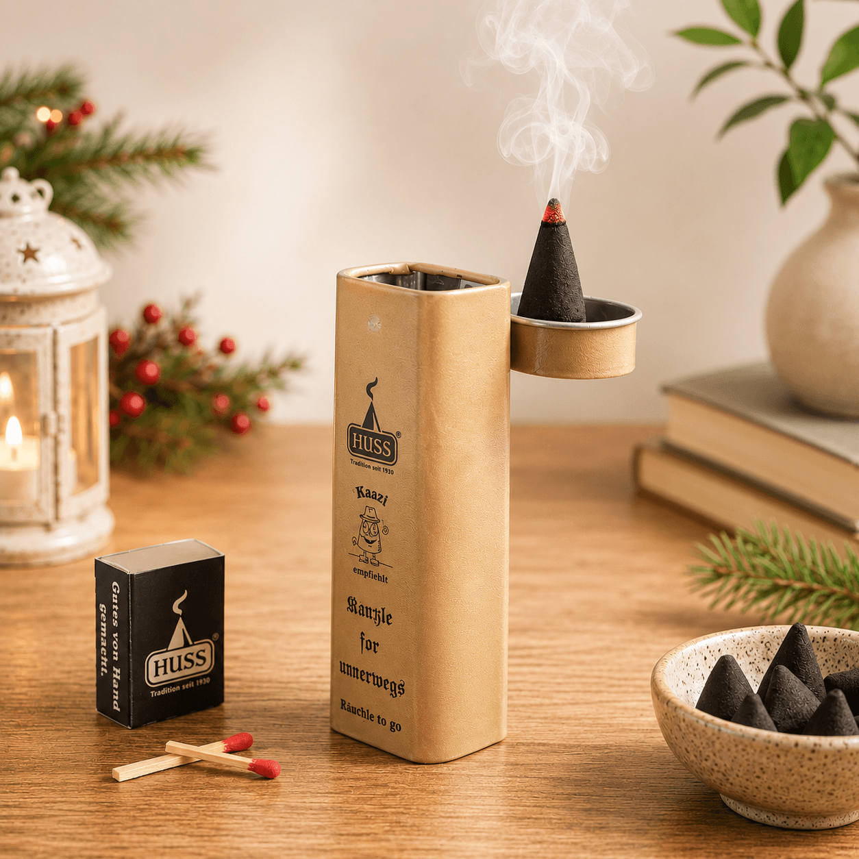 HUSS Incense Karl to go; incense holder in beige with a burning incense cone, matches, and incense cones displayed on a wooden table with Christmas decor.