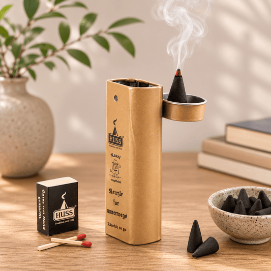 HUSS Incense Karl to go; incense holder in beige with a burning incense cone, matches, and incense cones displayed on a wooden table.