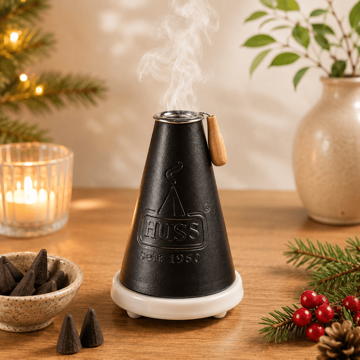 HUSS Incense Meiler black, incense burner with a burning incense cone and smoke rising, displayed on a wooden table with Christmas decor.