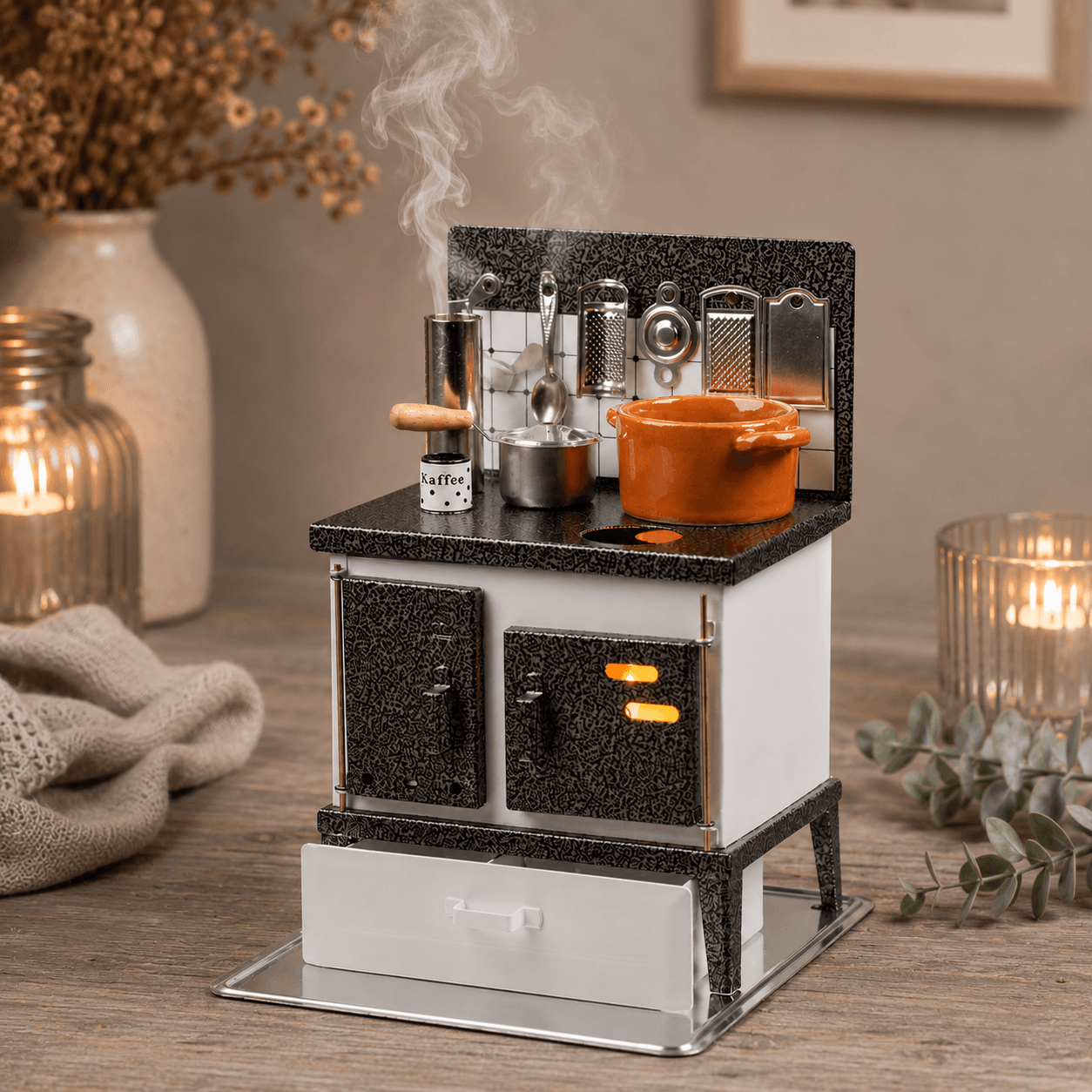 HUSS Incense white and silver multi-purpose oven with miniature cookware, kitchen utensils, and rising steam with cozy decor on a table.