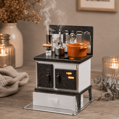 HUSS Incense white and silver multi-purpose oven with miniature cookware, kitchen utensils, and rising steam with cozy decor on a table.