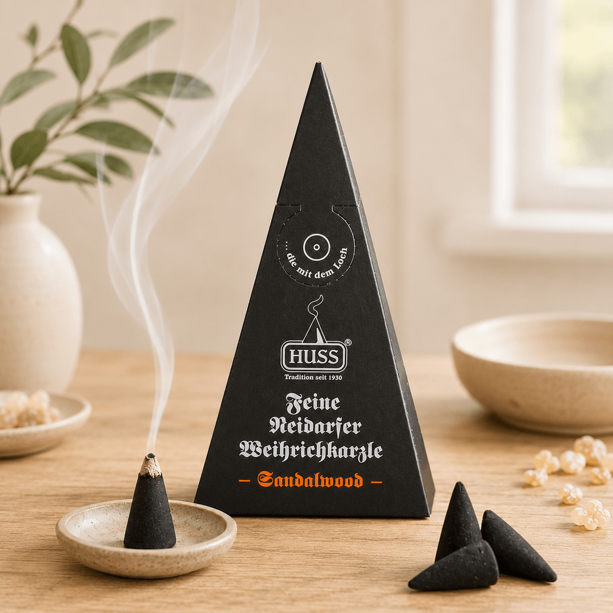 Fine Neudorf Incense cone box sandalwood with a smoking cone in a cozy setting and a window in the back.
