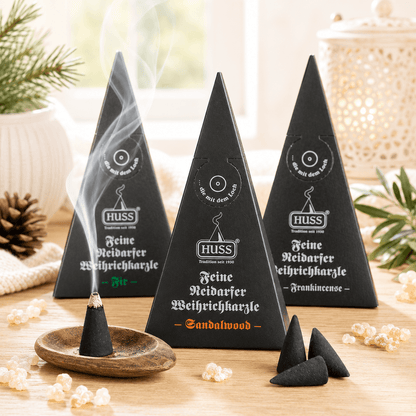 Three Fine Neudorf Incense cone boxes: frankincense, sandalwood, and fir, with a smoking cone displayed on a table.