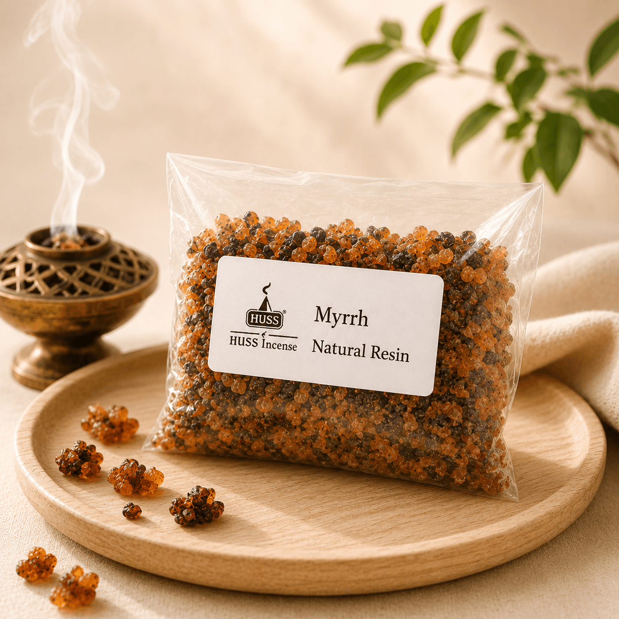 HUSS Myrrh Natural Resin in a clear resealable bag displayed on a wooden tray with scattered resin pieces and a smoking brass incense burner.