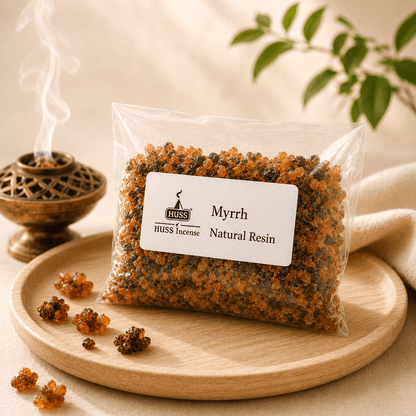 HUSS Myrrh Natural Resin in a clear resealable bag displayed on a wooden tray with scattered resin pieces and a smoking brass incense burner.