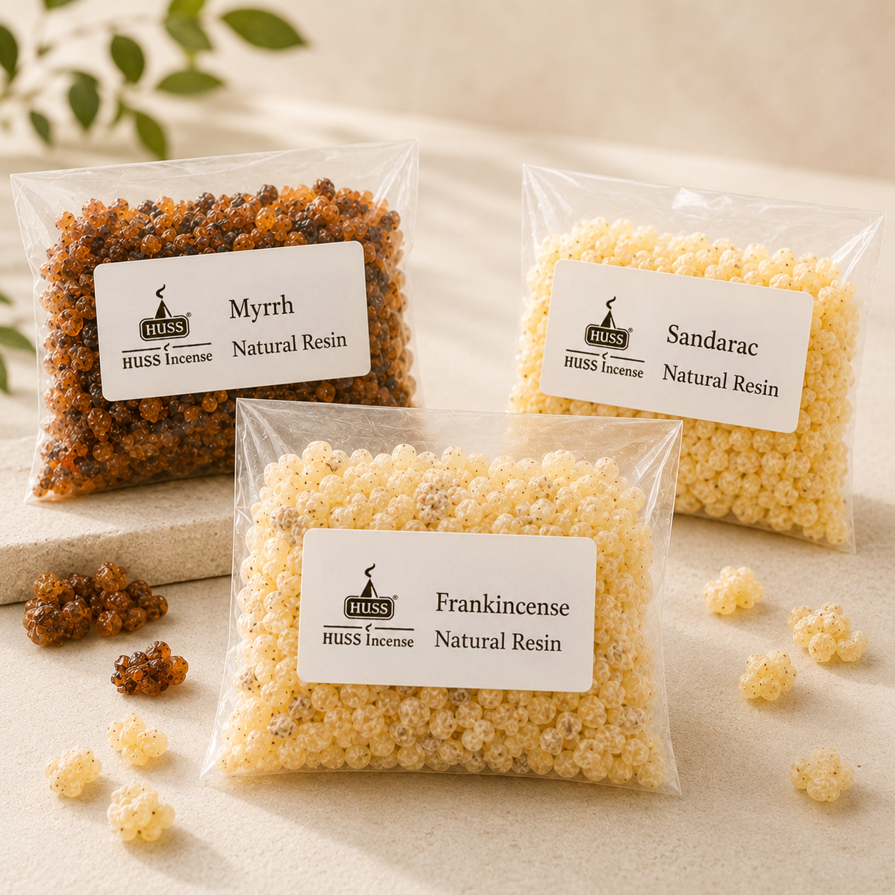 Three HUSS Incense natural resin bags in Myrrh, Frankincense, and Sandarac, displayed on a light beige surface with loose resin pieces scattered around.