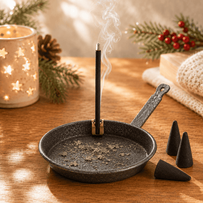 HUSS Incense #1 Rustic pan with smoking incense stick on a wooden table in a cozy setting with Christmas decor.
