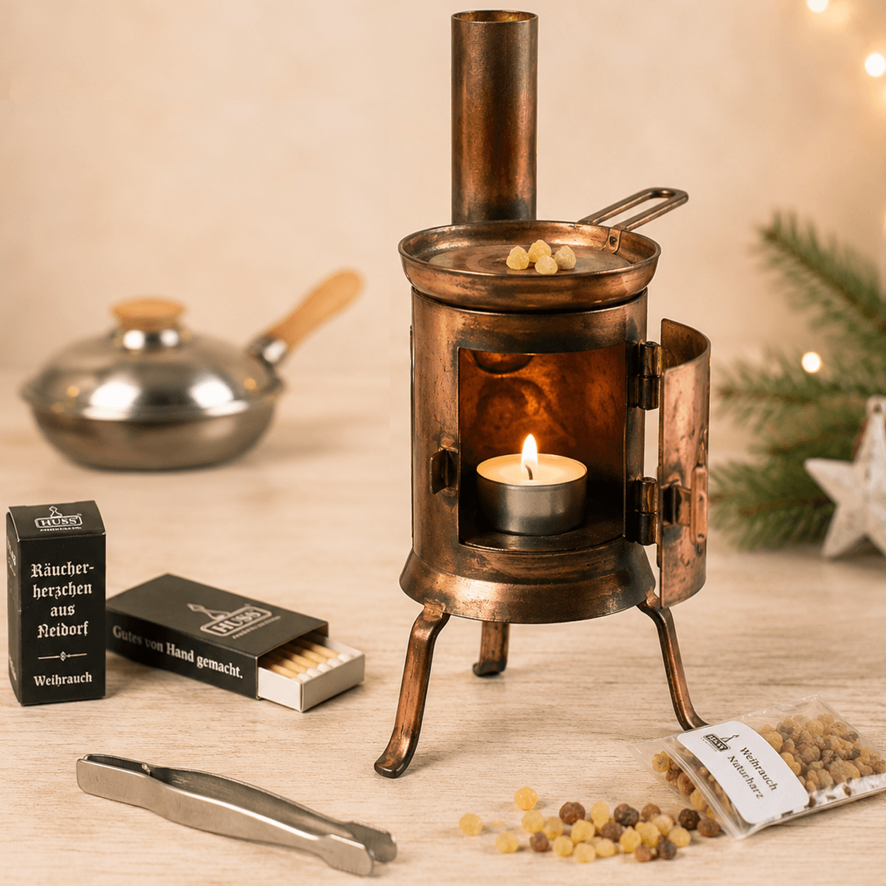 HUSS Incense Table Huss'l a copper oven burner with a lit tealight, natural frankincense resin, and resin accessories displayed on a wooden table.