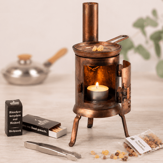 Small Table HUSS'l with an candle burning and some resin on top with accessories around