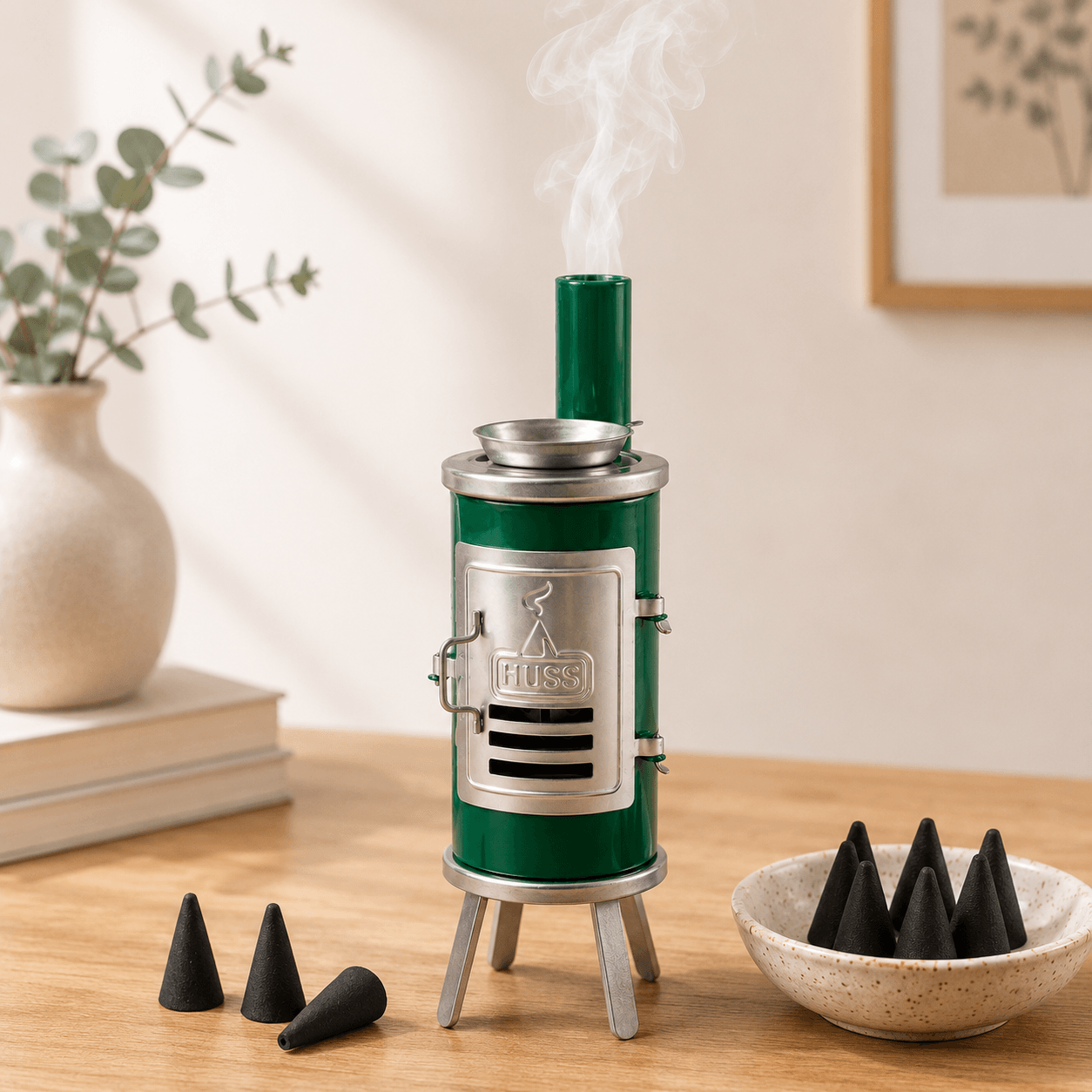HUSS Incense Glue oven green with silver accents, smoking chimney, and incense cone holder, displayed on a wooden table with incense cones in a cozy home setting.