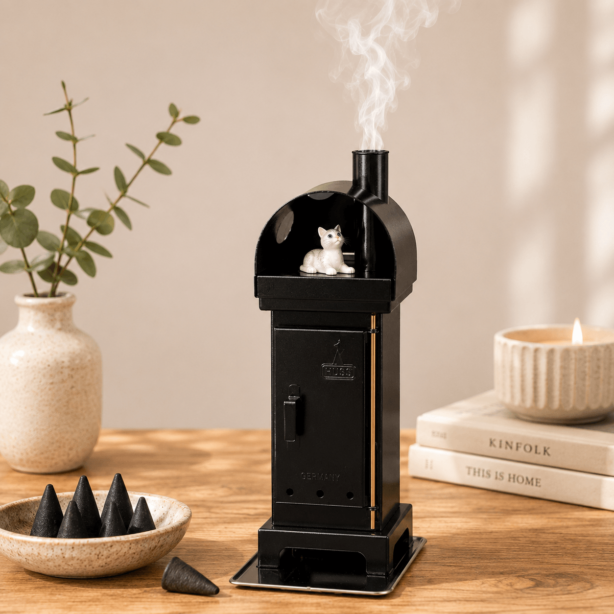 Copper HUSS Incense woodburner blackwith a cat steaming out of the chimney in a cozy setting.