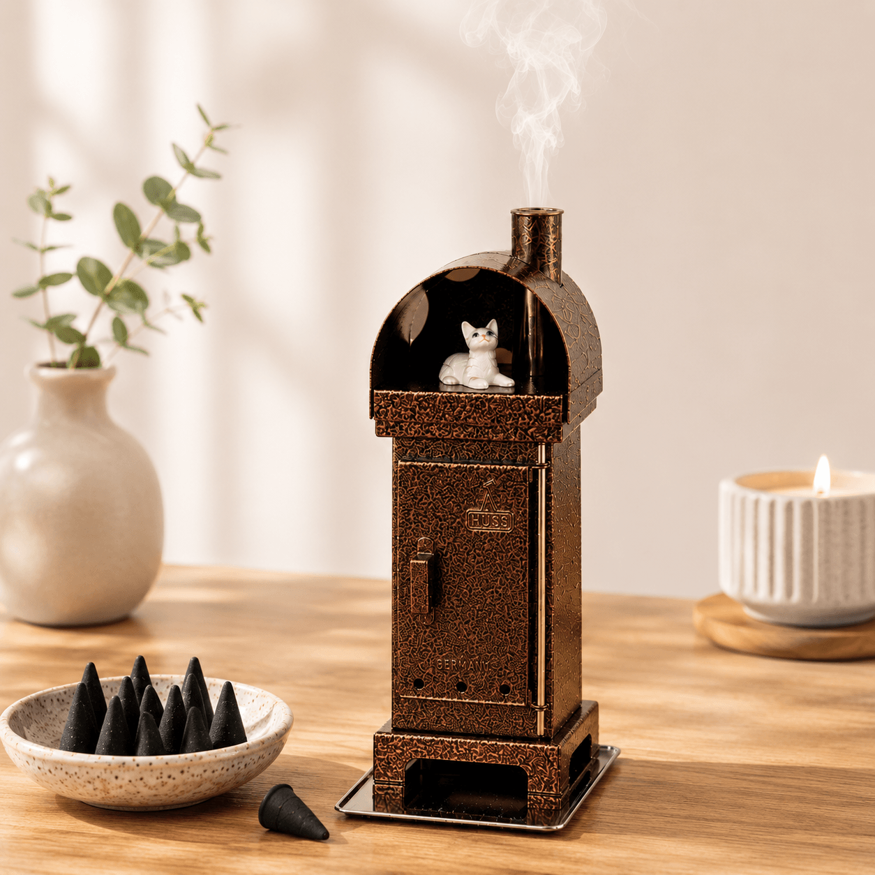 Copper HUSS Incense woodburner copper with a cat steaming out of the chimney in a cozy scene.