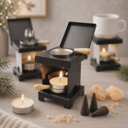 Video of a HUSS Incense stool stove black with a lit tealight, warming pan, incense cones, and natural resin displayed on a wooden table with more ovens in the background.