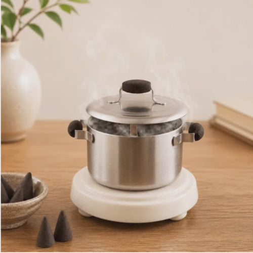 Video of a HUSS Incense Kettle in silver, incense burner with a burning incense cone and smoke rising, displayed on a wooden table.