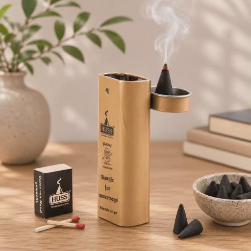 Video of a HUSS Incense Karl to go; incense holder in beige with a burning incense cone, matches, and incense cones displayed on a wooden table.