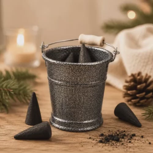 A Video of HUSS Incense bucket for storage with incense cones, and loose incense cones displayed moved on a wooden table.